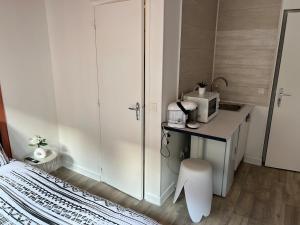 a bedroom with a bed and a counter with a microwave at Studio Zen - Paris à 5mn in Alfortville +6 photos