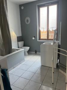 a bathroom with a tub and a toilet and a sink at Apt F2 1er étage centre ville face a l église in Rugles