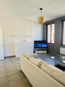 a living room with a couch and a tv at Apt F2 1er étage centre ville face a l église in Rugles