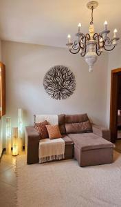 a living room with a couch and a chandelier at CASA OURO até seis pessoas com conforto pertim do Centro Histórico in Tiradentes
