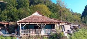 an old house with a thatched roof on a hill at Pensiunea din Deal in Prod