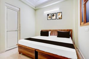 un dormitorio con una cama grande en una habitación en Hotel O Smile Sweet Hotel, en Kālkāji Devi