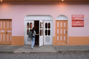 a woman is standing in front of a door at Macarena Hostel in Flores