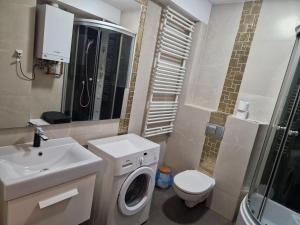 a bathroom with a washing machine and a sink at Apartamenty Centrum Studio Zagnańska in Kielce