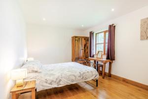 Un dormitorio con una cama y un escritorio y una ventana. en 3 Bed in Shebbear oc-l32583, en Shebbear