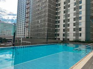 a large blue swimming pool next to a tall building at Modern & Cozy Homey Condo in Avida Riala Towers Cebu City IT Park T1 in Cebu City