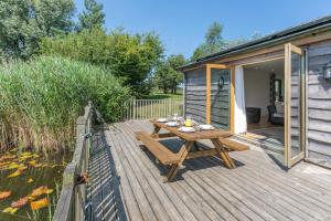 una terraza de madera con mesa de picnic y una casa en 3 Bed in Shebbear oc-l32582, en Shebbear