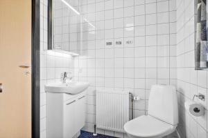 a white bathroom with a toilet and a sink at 2689-Nexo-Munkegardsskoven-6 in Neksø