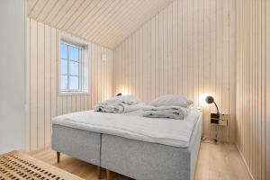 a bedroom with a bed with white walls and a window at 6809-Allinge-Aeblebakken-2 in Allinge