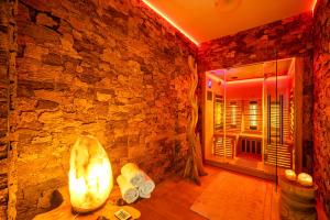 a bathroom with a stone wall and a room with a shower at Retreat Living - Business-Apartment mit 3 Schlafzimmern, 2 Bädern & Sauna - kostenloser Parkplatz in Bensheim