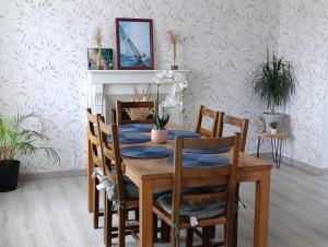 a dining room with a wooden table and chairs at Petite Maison a deux pas du centre in Le Faou