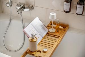 a wooden tray with a book on a bathroom counter at Retreat Living - Business-Apartment mit 3 Schlafzimmern, 2 Bädern & Sauna - kostenloser Parkplatz in Bensheim +16 photos