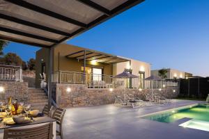 a villa with a swimming pool and a house at Emmanouil Private Villa A in Roumelí