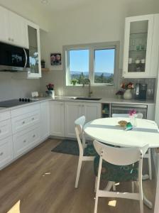 a kitchen with a white table and a table and chairs at Serene Forest Retreat in Sooke