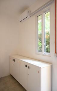 a kitchen with white cabinets and a window at Macarena Hostel in Flores +51 photos
