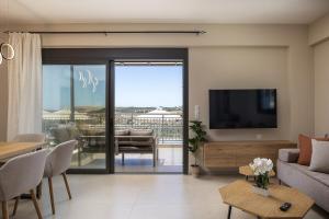 a living room with a television and a dining room at Emmanouil Private Villa A in Roumelí
