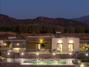 a building with a swimming pool at night at Emmanouil Private Villa A in Roumelí