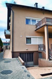 a house with two garage doors and a balcony at Hostel Art Gradiska in Bosanska Gradiška