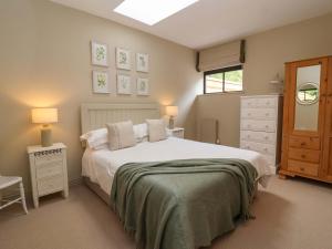a bedroom with a large white bed and a window at Old Cottage Hospital Annexe in Burford