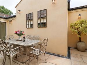 a patio with a table and chairs at Old Cottage Hospital Annexe in Burford