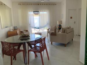 ein Wohnzimmer mit Tisch und Stühlen und einer Couch in der Unterkunft Casa dos cajueiros in Paracuru + 24 Fotos