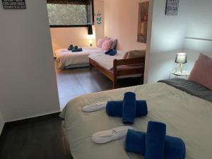 a bedroom with two beds with blue slippers on them at Chambres Élysées in Athens