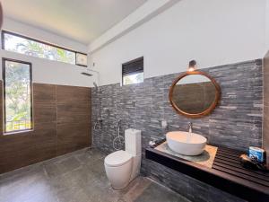Un baño con inodoro, lavabo y espejo. en Flourish Inn Ella, en Ella 16 fotos más