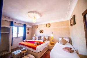 マラケシュにあるKOUTOBIA ROYALのベッド2台とソファのある寝室