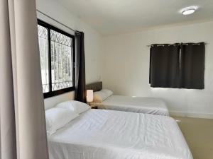 two beds in a room with a window at Casa Jalisco, Campeche 2 in Campeche +18 photos