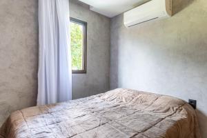 a bedroom with a bed and a window at Praça Cinco in Porto De Galinhas