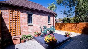 a patio with a table and chairs and flowers at Stylish Stratford upon Avon Stay - Gated Parking - Sleeps 6 in Stratford-upon-Avon