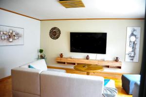 a living room with a couch and a flat screen tv at Dein Ferienhaus in Kärnten, Bad Bleiberg - Erholung, Natur und Komfort in Bad Bleiberg