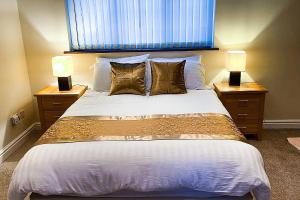 a bedroom with a large bed with two lamps at Stylish Stratford upon Avon Stay - Gated Parking - Sleeps 6 in Stratford-upon-Avon