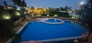 Una gran piscina azul por la noche en The Glass Loft, en Nairobi