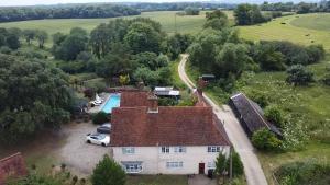 an aerial view of a house with a pool at Grade II Listed Farmhouse, Pool, Hot Tub, Games Room, Celebration Hall, Car Park, 10ppl, 45 min from Central London in Stapleford Tawney