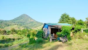 ein kleines Haus mit einem davor geparkten Motorrad in der Unterkunft Tiny House Balas in Maluk