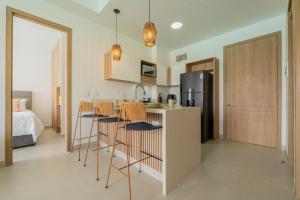 a kitchen with bar stools and a kitchen with a refrigerator at Baia Crystal Luxury Stay - Penthouse Vista a la Laguna in Cartagena de Indias