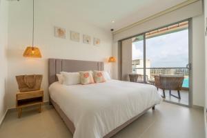 a bedroom with a large white bed and a balcony at Baia Crystal Luxury Stay - Penthouse Vista a la Laguna in Cartagena de Indias +53 photos