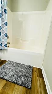 a room with a white wall and a rug on the floor at Vacay escape, rooms in Charlotte in Charlotte +39 photos