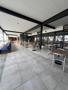 a restaurant with tables and chairs and windows at Blyde Lagoon in Pretoria