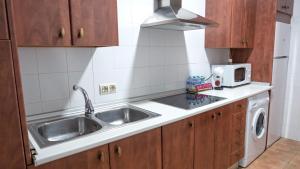 a kitchen with a sink and a microwave at Casas Rurales Ramírez in Ossa de Montiel