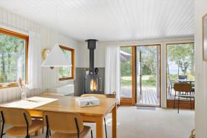 a dining room with a table and a fireplace at 4705-Aakirkeby-Sondre-Landevej-60 in Åkirkeby +16 photos