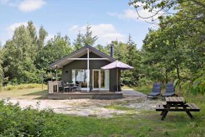a small cabin with a picnic table and chairs at 4705-Aakirkeby-Sondre-Landevej-60 in Åkirkeby