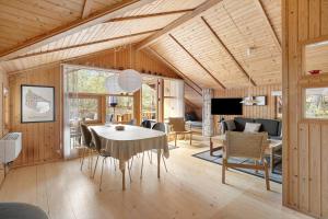 a dining room with a table and a living room at 2544-Nexo-Skovsangervej-29 in Neksø