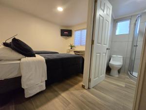 a bedroom with a bed and a bathroom with a toilet at AH Hotel in Antofagasta