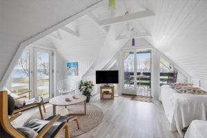 a white living room with a bed and a tv at 3688-Nexo-Olssonsvej-1 in Neksø