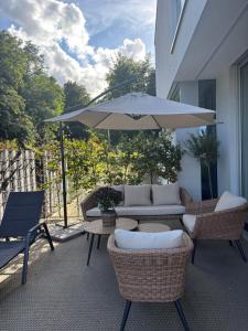 a patio with a table and an umbrella at Wunderschöne Wohnung nahe Köln und Düsseldorf in Dormagen