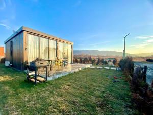 a small house with a grill in the grass at Sagu in Saguramo
