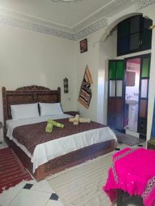 a bedroom with a large bed with two stuffed animals on it at Riad Andalousse in Meknès +33 photos