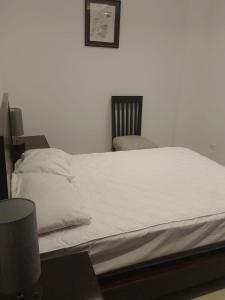 a white bed with a chair in a room at Fontaine Bleau Tonsupa, Ecuador in Volcán Chimborazo